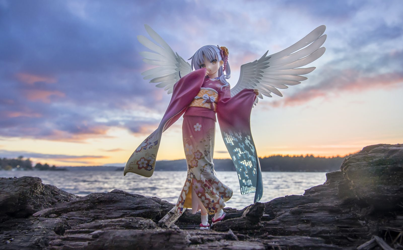 Winged figure on rocky shore
