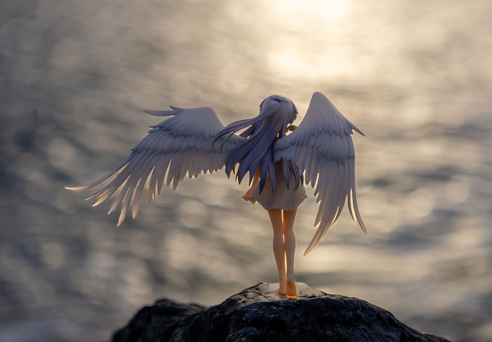 Winged figure with bokeh water